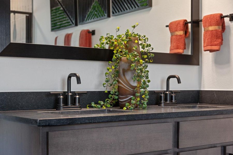 The Black Mist granite countertop is featured here with the Moen Gibson bathroom faucet in Matte Black.