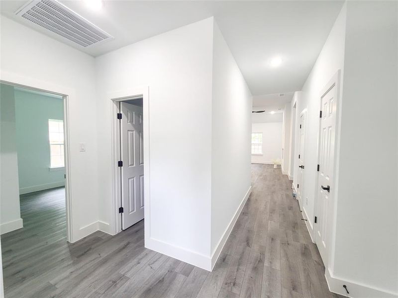 Hallway with light wood-style flooring and baseboards Hallway with light wood-style flooring and baseboards