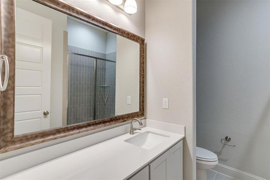 Bathroom featuring vanity, toilet, and tile patterned floors