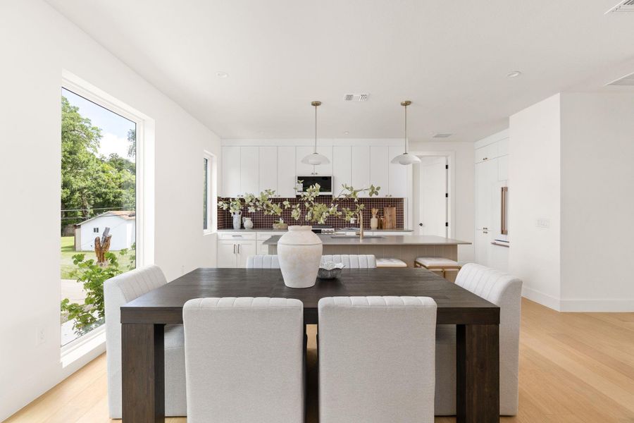 An open concept design seamlessly connects the dining area with a contemporary kitchen. An open concept design seamlessly connects the dining area with a contemporary kitchen.