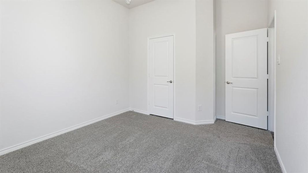 Neutral tone walls with white trim and grey carpet flooring