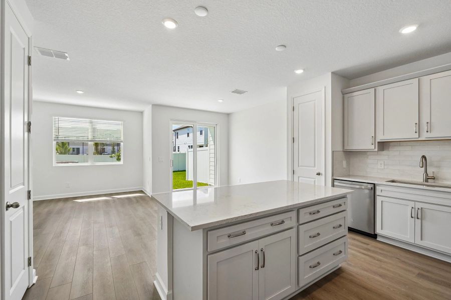 As you continue down the foyer you are welcomed into an open concept kitchen, dining and family room space