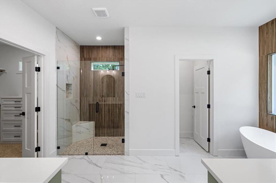 Full bathroom featuring a marble finish shower, a freestanding tub, light marble finish floors, vanity, and recessed lighting Full bathroom featuring a marble finish shower, a freestanding tub, light marble finish floors, vanity, and recessed lighting