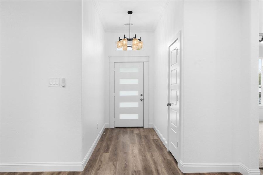 Entrance foyer with wood-type flooring and ornamental molding