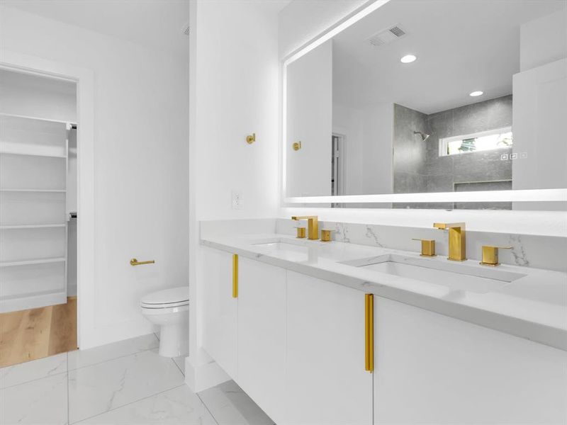 Bathroom featuring a tile shower, hardwood / wood-style floors, vanity, and toilet