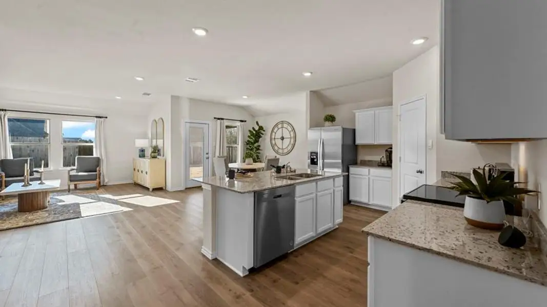 Kitchen featuring light stone counters, stainless steel dishwasher, a center island with sink, recessed lighting, and dark wood-style floors