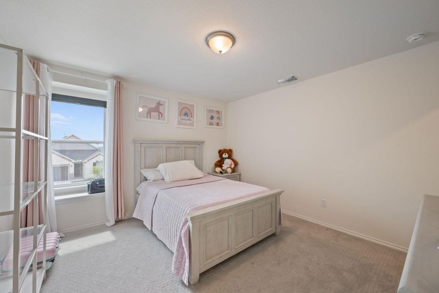 Bedroom featuring light carpet and baseboards Bedroom featuring light carpet and baseboards