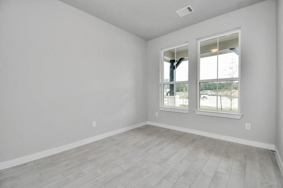Step into the inviting home office, where elegant tile flooring adds a touch of freshness and comfort to the workspace. Natural light pours through the window, creating an inspiring environment for productivity and focus. Sample photo of completed home with similar floor plan. Actual colors and selections may vary.
