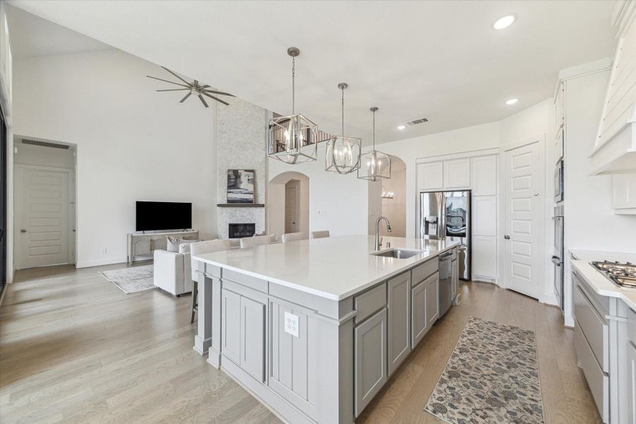 The kitchen has two tone cabinets with the gray (lower) and the white on the (uppers). Polished light colored quartzite countertops, large set of triple pendant lights, walk in pantry, pots and pan drawers and plenty of storage space. The kitchen has two tone cabinets with the gray (lower) and the white on the (uppers). Polished light colored quartzite countertops, large set of triple pendant lights, walk in pantry, pots and pan drawers and plenty of storage space.