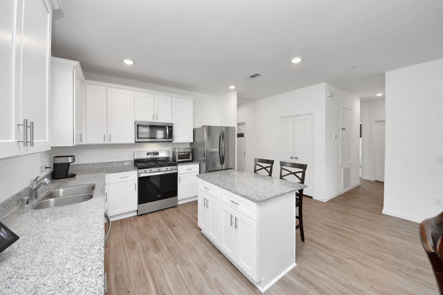 Greeted by open floor plan kitchen/dining/living area