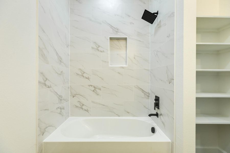 Tub/Shower combo surrounded by quartz countertops