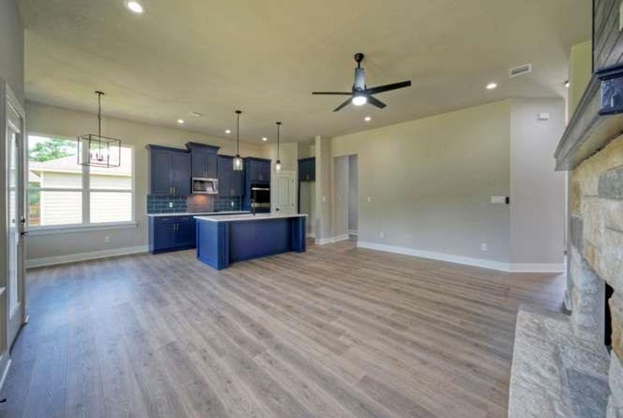An open-concept living space with a contemporary kitchen and durable flooring provides modern comfort.