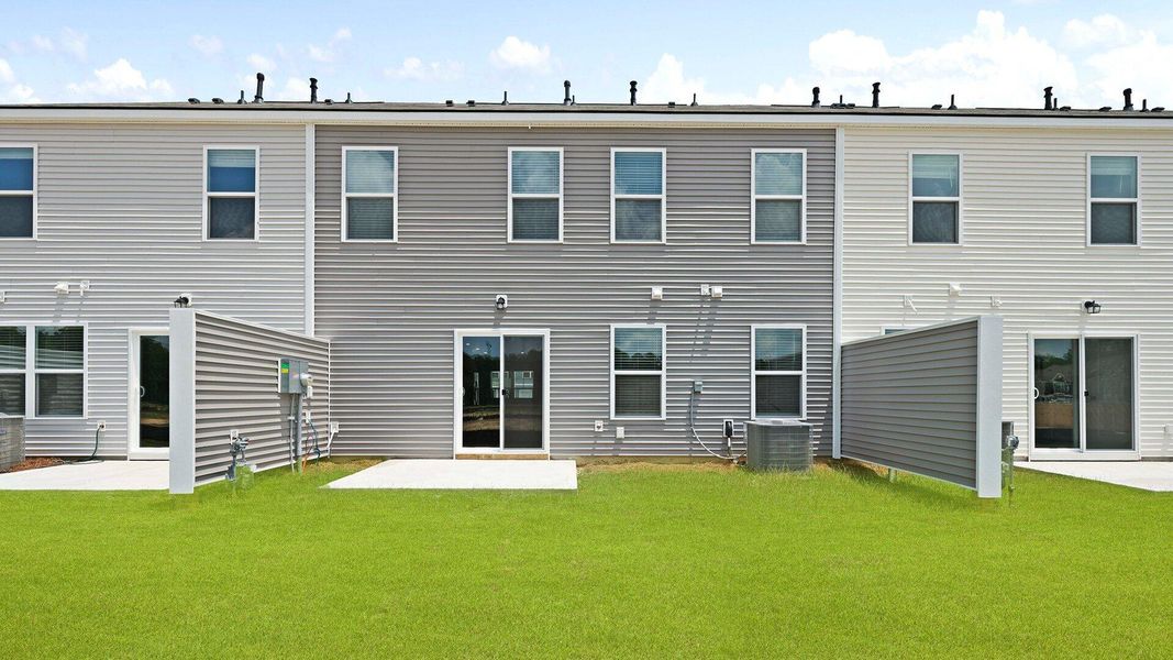 Front exterior of a new home in Pine Hills Townhomes at Cane Bay, Summerville, SC, highlighting curb appeal (Image 1). Front exterior of a new home in Pine Hills Townhomes at Cane Bay, Summerville, SC, highlighting curb appeal (Image 1).