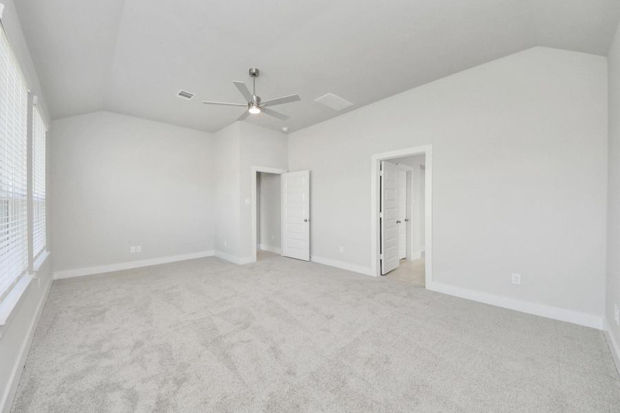 Escape to tranquility in this spacious primary room, adorned with plush carpeting and bathed in the soothing hues of warm paint colors, creating a cozy retreat for relaxation. Sample photo of completed home with similar floor plan. Actual colors and selections may vary.