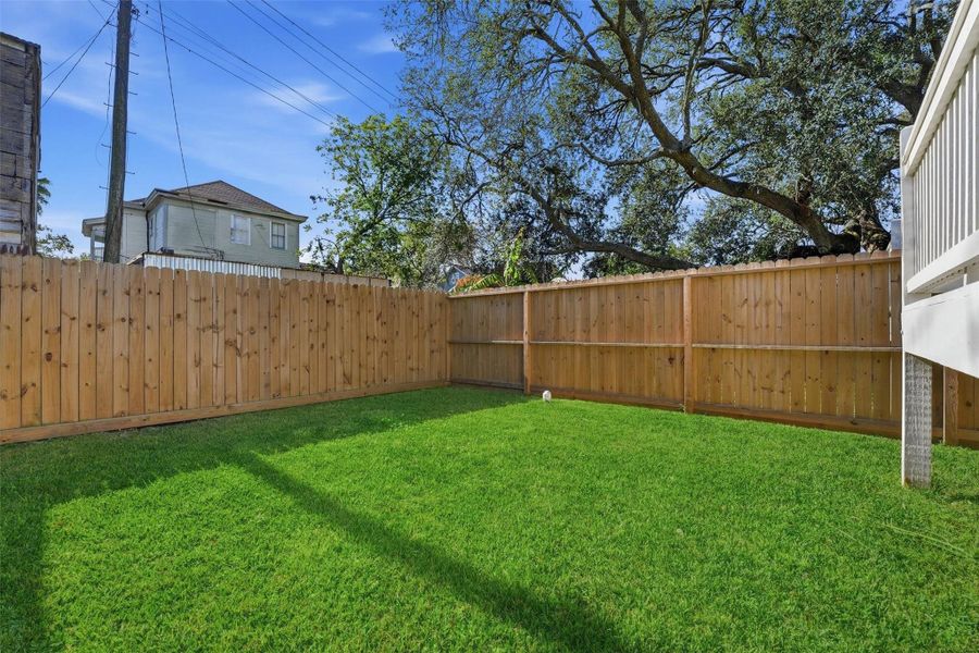 The spacious, fenced yard offers room for outdoor activities, entertaining, or pets, creating valuable private outdoor space rarely found with new construction.