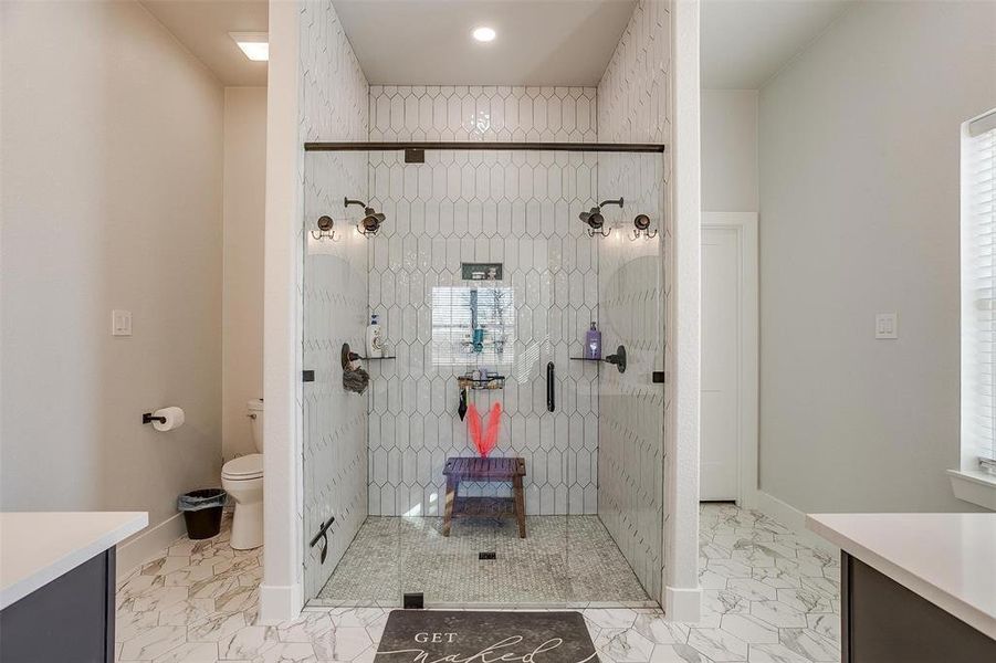 Bathroom featuring vanity, a shower, and toilet