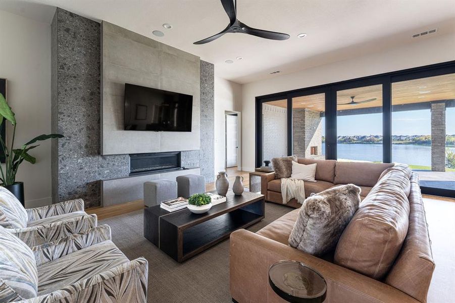 Living room featuring ceiling fan and a large fireplace