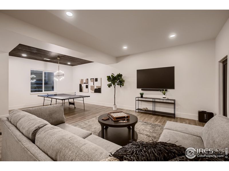 Built in speakers and wood paneled ceiling in media area