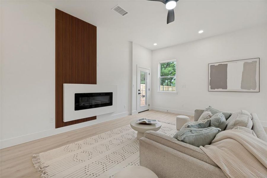 Modern living area featuring a wall-mounted electric fireplace with a slatted accent wall