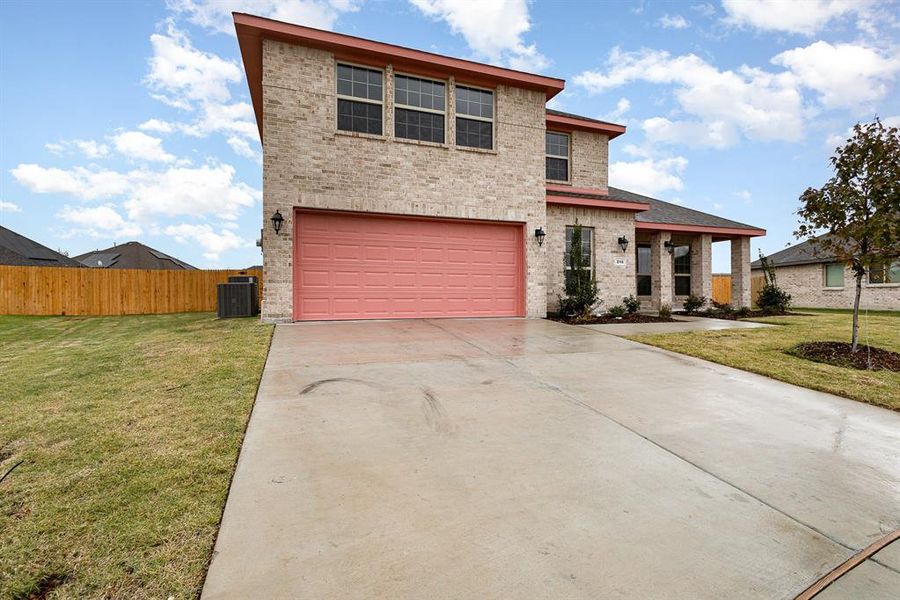 View of front of property with cooling unit, a front lawn, and a garage