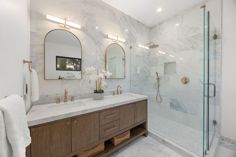 Double vanity with wood-finish cabinetry, quartz countertops, and dual vessel sinks