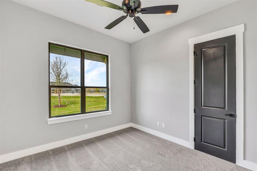 Carpeted empty room with ceiling fan