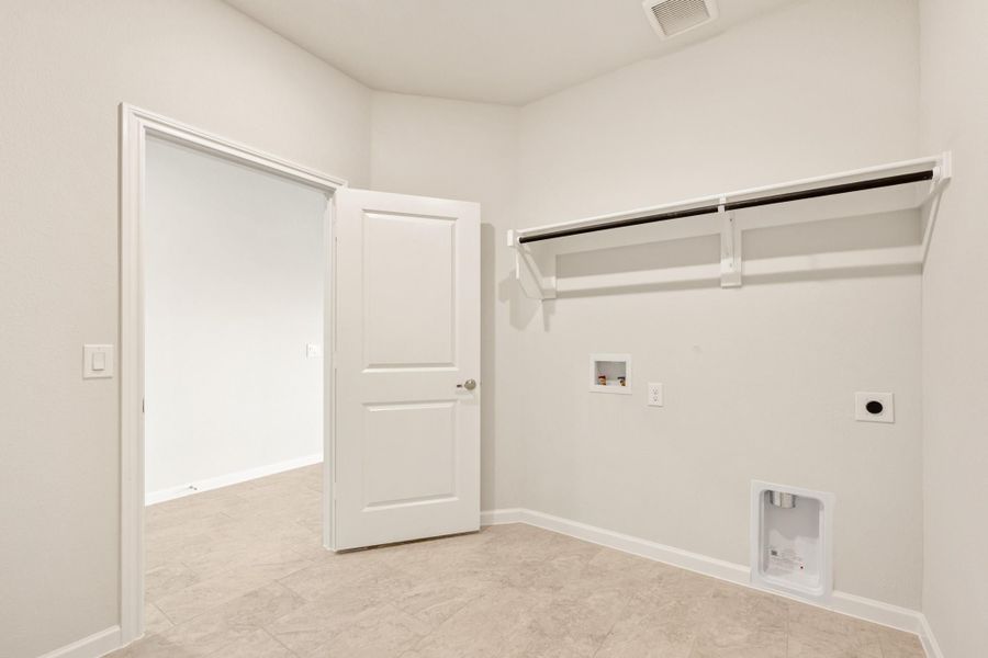 Empty laundry room with wall-mounted drying rack, washer hookups, and tile floor