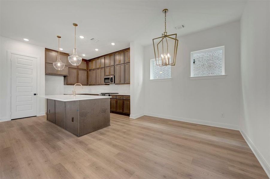 Open-concept kitchen and dining area with wood-finish flooring
