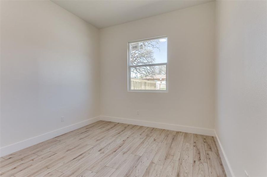 Unfurnished room with wood finished floors and baseboards