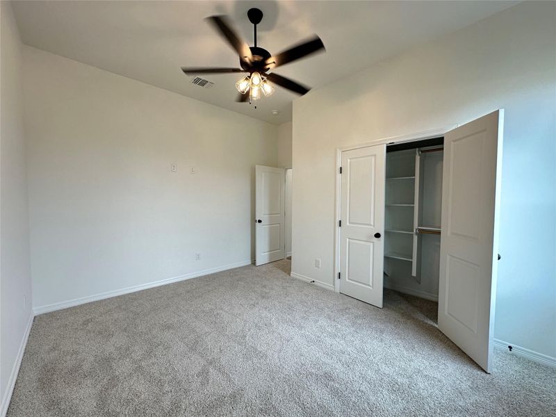 Unfurnished bedroom featuring a closet, a ceiling fan, and light carpet
