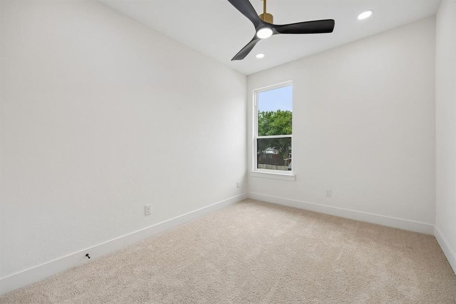 Spacious room featuring neutral carpet flooring, recessed lighting, and a modern ceiling fan Spacious room featuring neutral carpet flooring, recessed lighting, and a modern ceiling fan