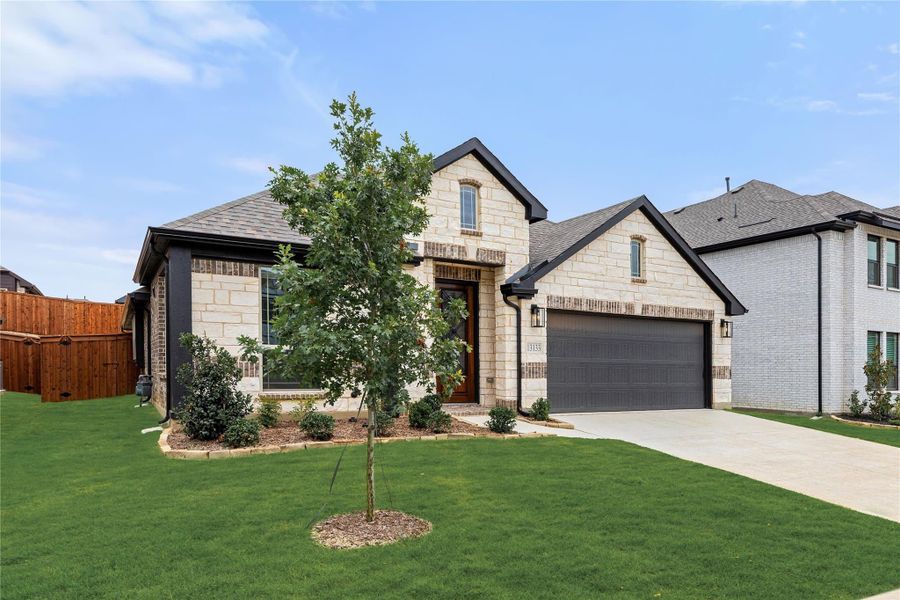 Two-story home with stone and brick exterior, two-car garage, and landscaped front yard Two-story home with stone and brick exterior, two-car garage, and landscaped front yard