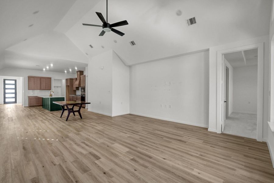 The dining and living areas have a vaulted ceiling with recessed lighting and a five blade ceiling fan.