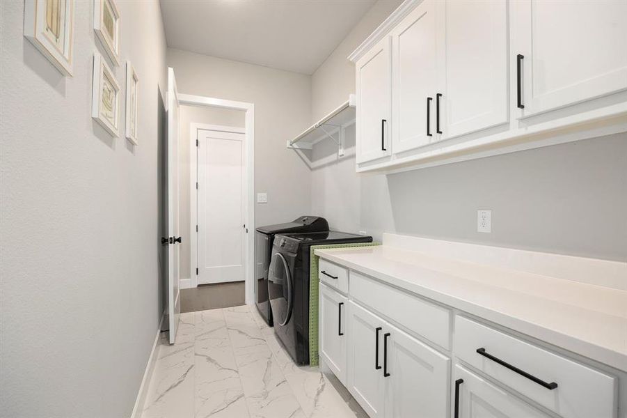 Laundry room featuring cabinets and washer and dryer