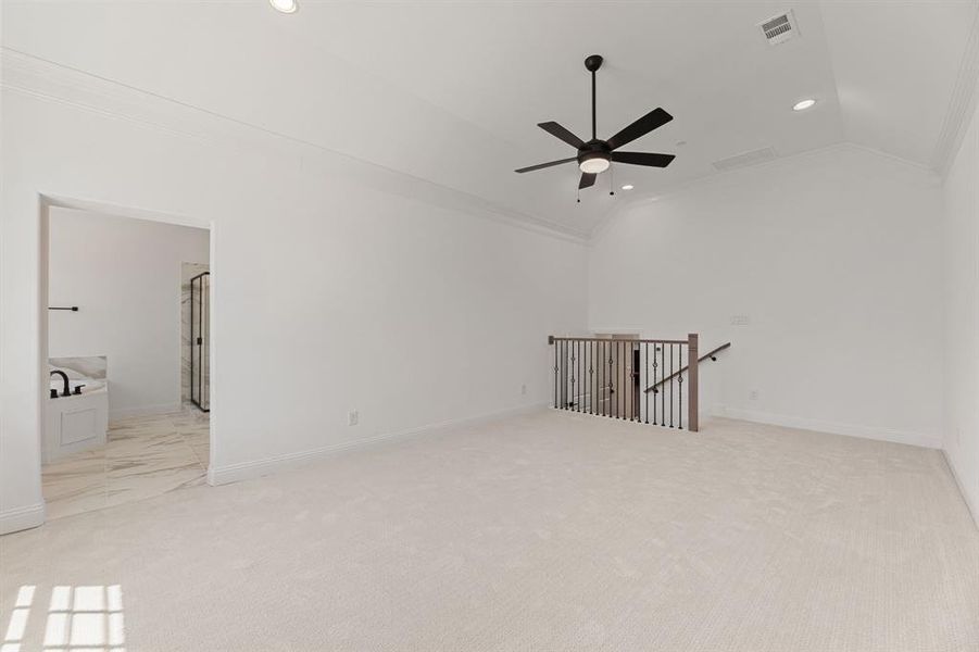 Empty room featuring lofted ceiling, recessed lighting, ornamental molding, light colored carpet, and a ceiling fan Empty room featuring lofted ceiling, recessed lighting, ornamental molding, light colored carpet, and a ceiling fan