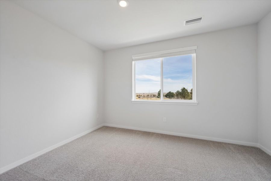 A room with a window and a white wall with a view of the ocean.