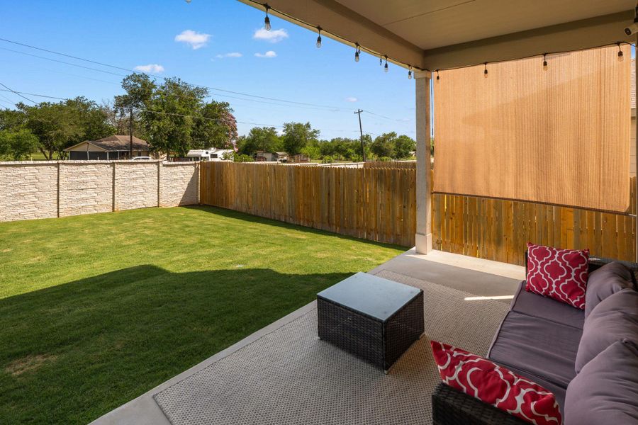 A spacious backyard with a manicured lawn is enclosed by privacy fencing and offers a covered patio area. Light colored wall maintained by HOA. A spacious backyard with a manicured lawn is enclosed by privacy fencing and offers a covered patio area. Light colored wall maintained by HOA.