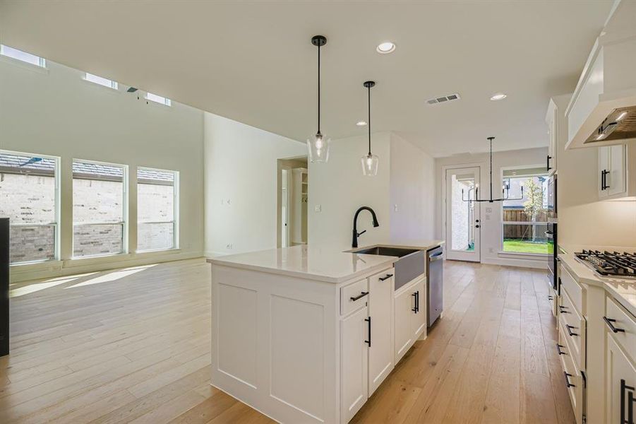 Kitchen with white cabinets, pendant lighting, a center island with sink, light wood-type flooring, and recessed lighting Kitchen with white cabinets, pendant lighting, a center island with sink, light wood-type flooring, and recessed lighting