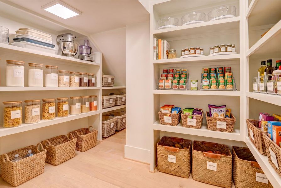 The pantry offers plenty of built-in storage space, including a cleaning section with an outlet for your vacuum.