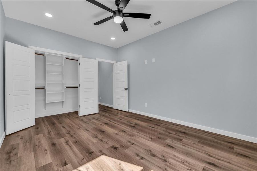 Unfurnished bedroom featuring dark wood-style flooring, a ceiling fan, a closet, and recessed lighting Unfurnished bedroom featuring dark wood-style flooring, a ceiling fan, a closet, and recessed lighting