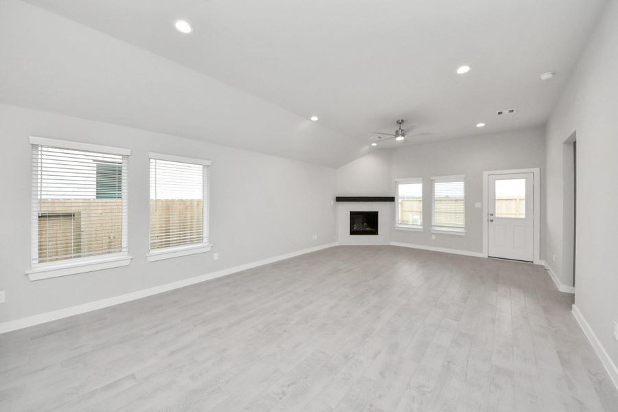 Gather the family and guests together in your lovely living room! Featuring soaring high ceilings, recessed lighting, ceiling fan, custom paint, gorgeous floors, and large windows that provide plenty of natural lighting throughout the day. Sample photo of completed home with similar floor plan. Actual colors and selections may vary.