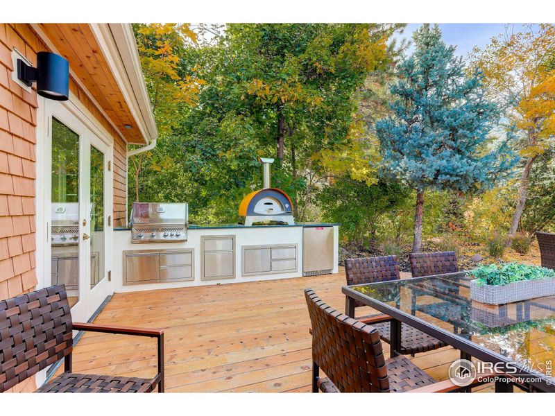 The private back yard patio features a custom built outdoor kitchen featuring Napoleon grill, refrigerator, trash and storage cabinets