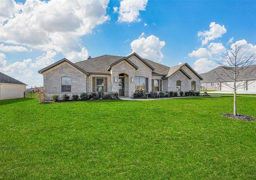 French country inspired facade with a front yard