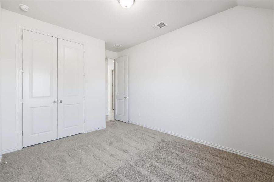 Unfurnished bedroom featuring carpet floors and a closet Unfurnished bedroom featuring carpet floors and a closet