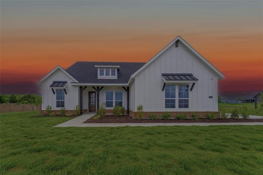 The property features a white exterior with board and batten siding, a dark roof, and brick accents