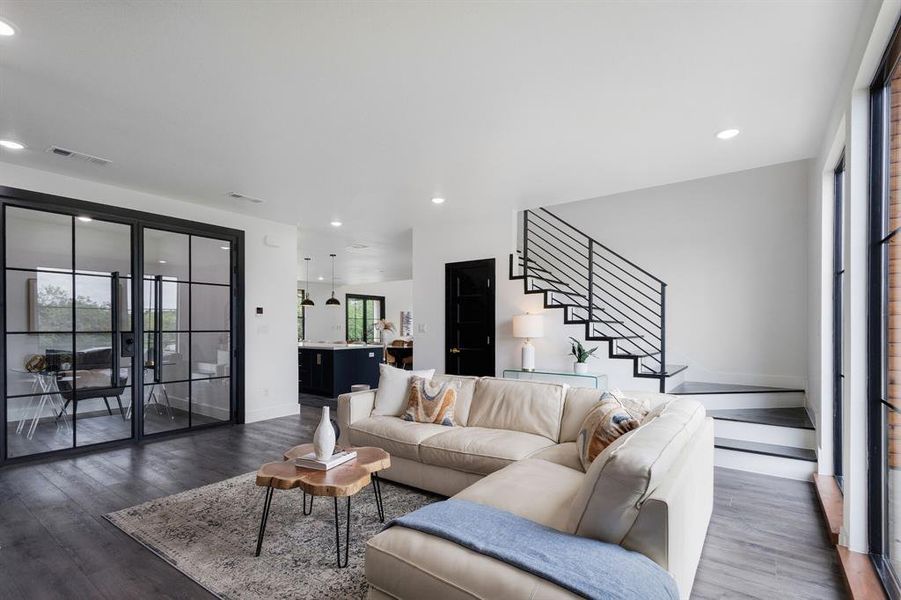 Open-concept living space featuring dark wood-finish flooring, recessed lighting, and large windows Open-concept living space featuring dark wood-finish flooring, recessed lighting, and large windows