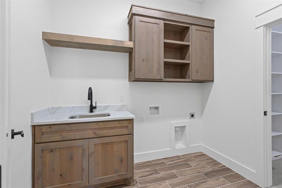 Laundry area with hookup for an electric dryer, wood finish floors, cabinet space, and washer hookup Laundry area with hookup for an electric dryer, wood finish floors, cabinet space, and washer hookup