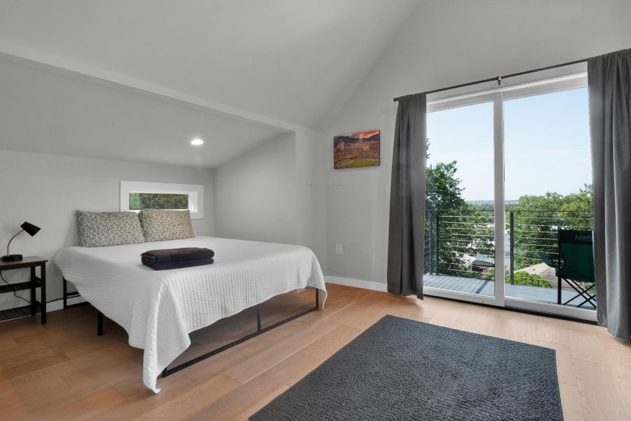 Bedroom with multiple windows, high vaulted ceiling, wood finished floors, and recessed lighting