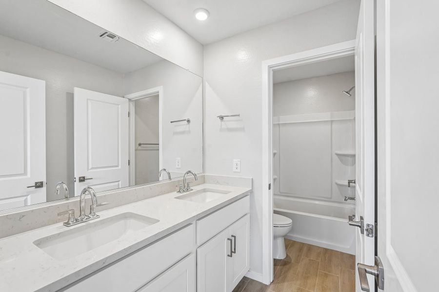 A bathroom with a tub sink and toilet.