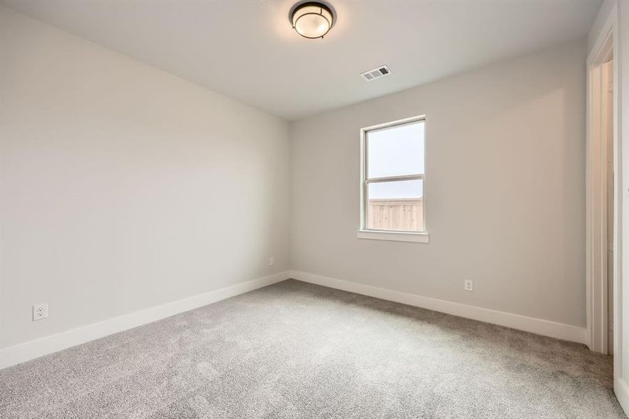 Carpeted empty room with baseboards and visible vents Carpeted empty room with baseboards and visible vents